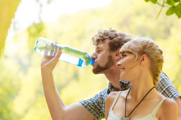 istock couple hikers resting in forest drinking water 1011271532