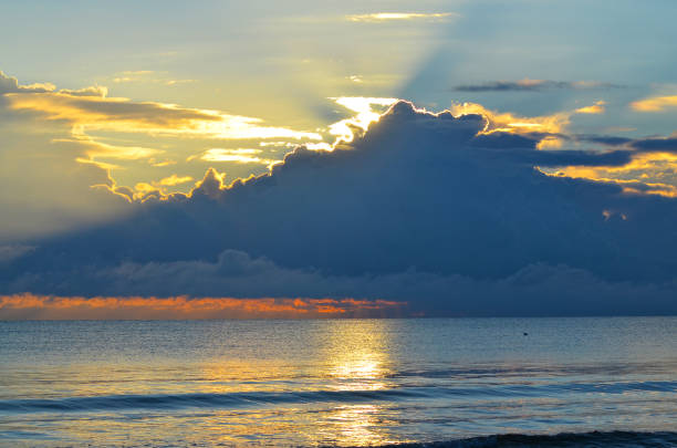 istock Dramatic light mood with orange illuminated clouds during a sunrise over the Baltic Sea in Binz on Ruegen, Germany 1011271622