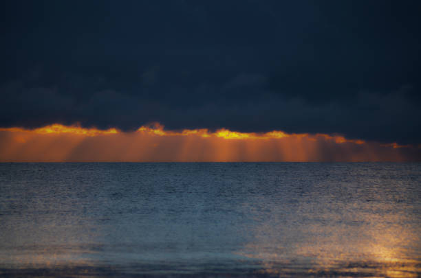 istock Dramatic light mood with orange illuminated clouds during a sunrise over the Baltic Sea in Binz on Ruegen, Germany 1011271660