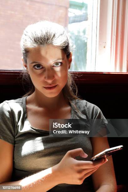 Social Manners Mobile Phone Reading Text In Public House Stock Photo - Download Image Now