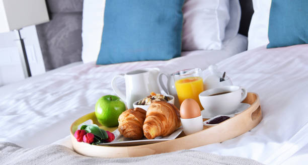 istock Breakfast on tray in bed in hotel room 1011279690