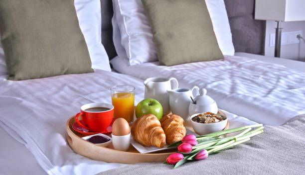 istock Breakfast on tray in bed in hotel room 1011279800