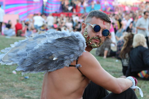 Sexy man with wings and glitter beard in music festival Sexy man with wings and glitter beard in music festival. dance  electronic music photos stock pictures, royalty-free photos & images