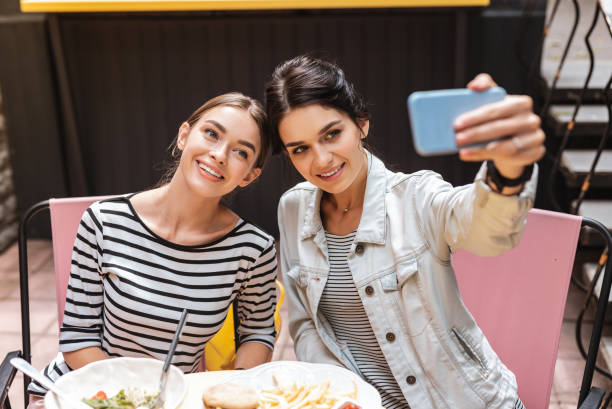 istock Two beaming appealing women making selfie together 1011284594