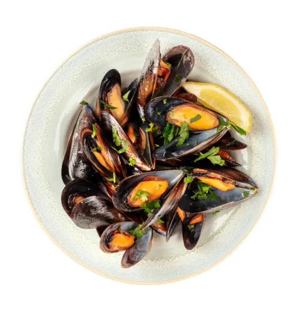 An overhead photo of a plate of cooked mussels, shot from above on a white background, isolated with a clipping path