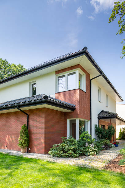 istock House with red brick wall with green grass and garden under sky 1011284738