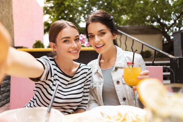 istock Smiling woman wearing jeans jacket drinking cocktail 1011284760