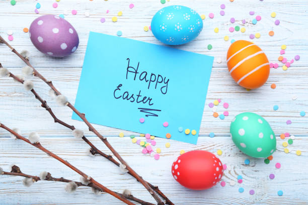 istock Inscription Happy Easter with painted eggs and branches on wooden table 1011287572