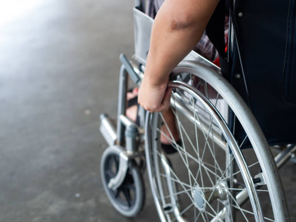 無効に男は、車椅子に座っています。彼は、ホイールに彼の手を保持しています。障害者概念。 - working people physical impairment wheelchair ストックフォトと画像