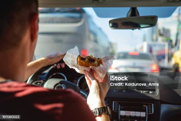 Man Driving Car While Eating Hamburger Stock Photo - Download Image Now - Eating, Car, Driving