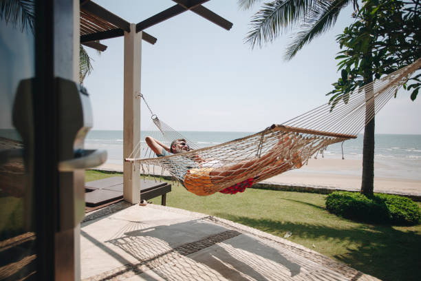 istock Couple relaxing in a hammock by the beach 1011313674