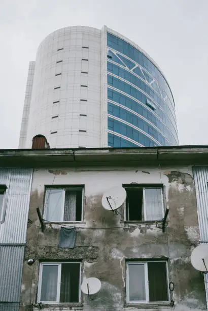 Photo of The contrast between low-income households and modern business building