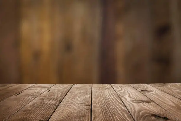 Empty wood table with defocused vertical table background. Ideal for product display on top of the table. Predominant color is brown. DSRL studio photo taken with Canon EOS 5D Mk II and Canon EF 24-105mm f/4L IS USM Wide Angle Zoom Lens