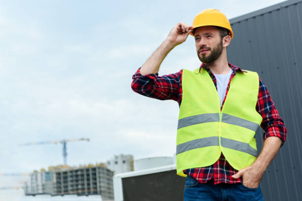 istock professional confident engineer in safety vest and helmet posing on roof 1011317494