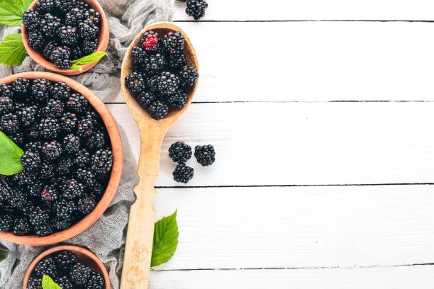 istock Fresh berries blackberries. On a white wooden background. Top view. Free space for text. 1011324422