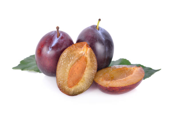 istock whole and half cut fresh prunes with leaf on white background 1011331984
