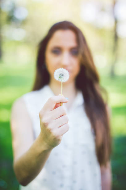 istock Brunette girl holding a dandelion 1011332436