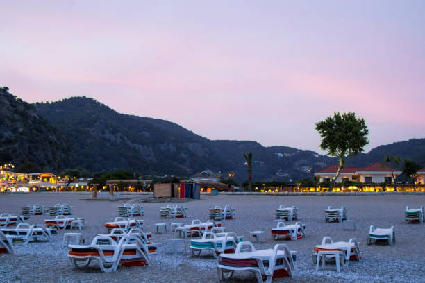istock Sunset, there are sun beds on the beach, evening lights are on 1011337000