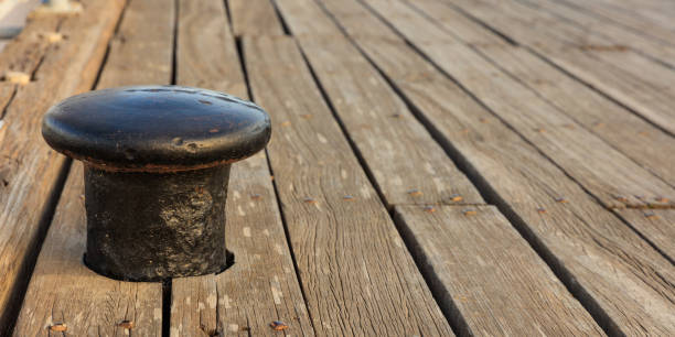 istock Black bollard mooring on wooden deck background. Closeup view with details, Copy space 1011349730