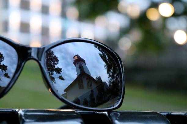 istock Reflection of lighthouse in sunglasses at twilight 1011354388