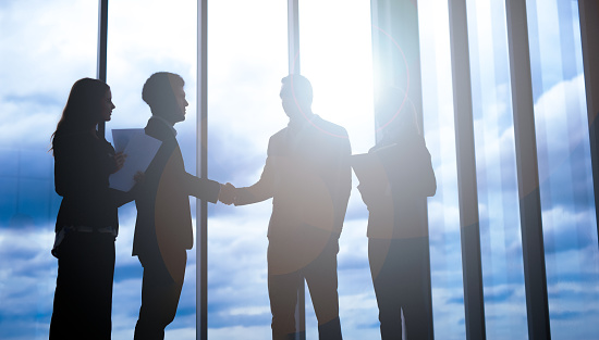 Silhouettes of business partners handshaking with man . handshake of business concept.
