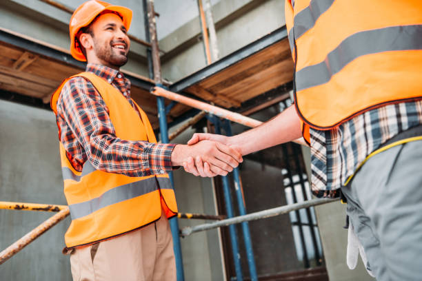 istock cropped shot of builders shaking hands at construction site 1011361004