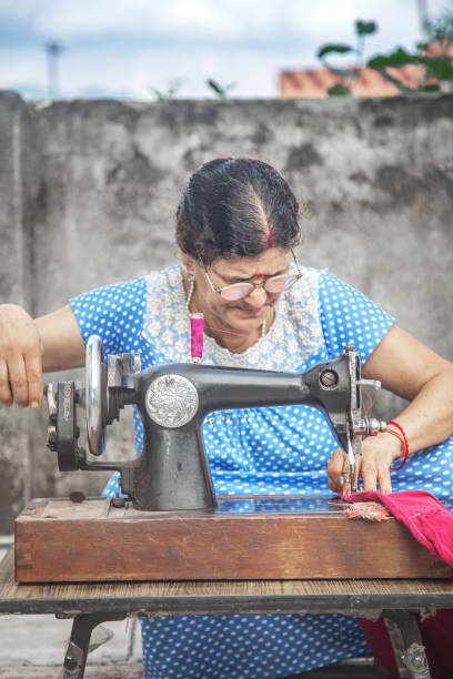 istock Indian woman sewing clothes with sewing machine 1011361106