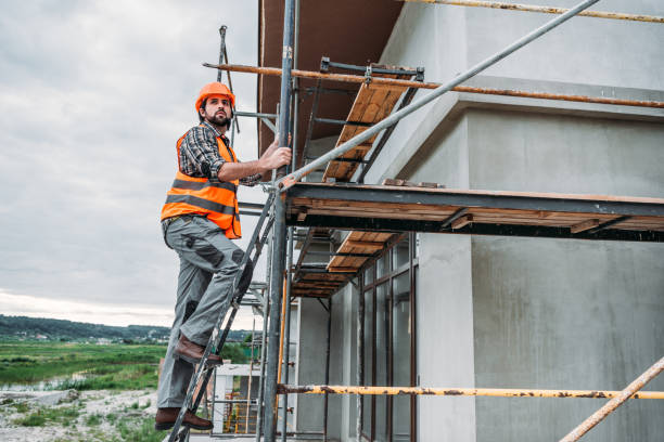 istock builder climbing on scaffolding at construction site and looking away 1011361180