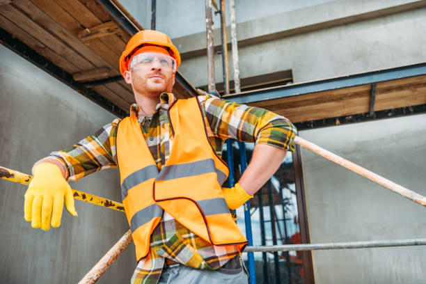 istock handsome builder leaning on scaffolding at construction site and looking away 1011361200