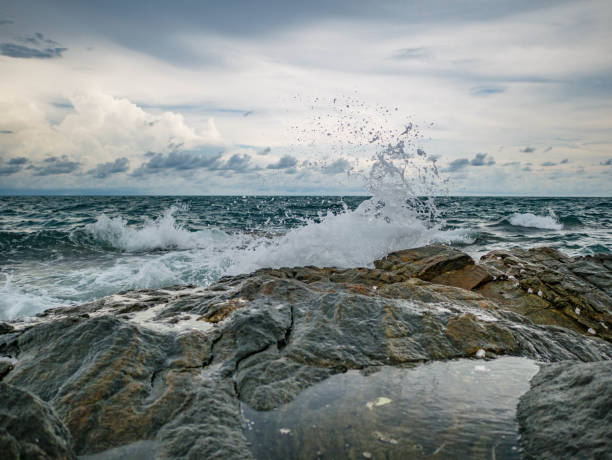 istock Ocean wave crashing Onto Rocky in the Blue ocean 1011361444