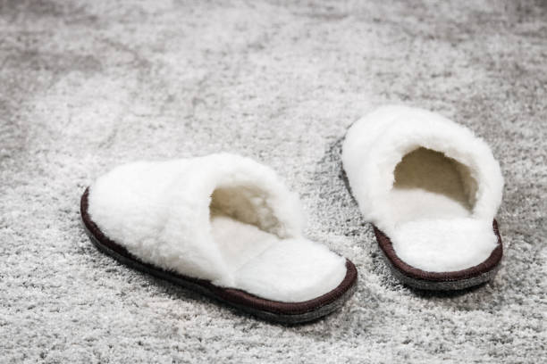 istock furry home Slippers white color on the carpet 1011361944