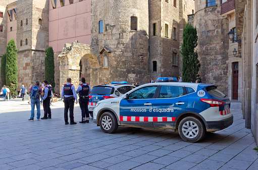 Barcelona, Spain  - April 21, 2018: Policemen and police car in Barri Gotic (Gothic Quarter)