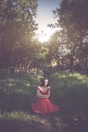 White Girl In Red Gown Kneeling Down Stock Photo - Download Image Now ...