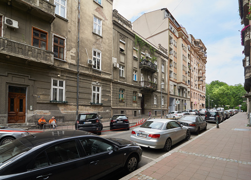 Belgrade, Serbia - May 04, 2018: Two elderly men in orange shirts have rest outdoors near their house on Gospodar Jovanova street