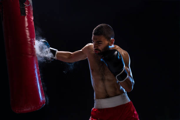 istock Muscular handsome boxer giving a forceful forward kick during a practise round with a boxing bag 1011376022