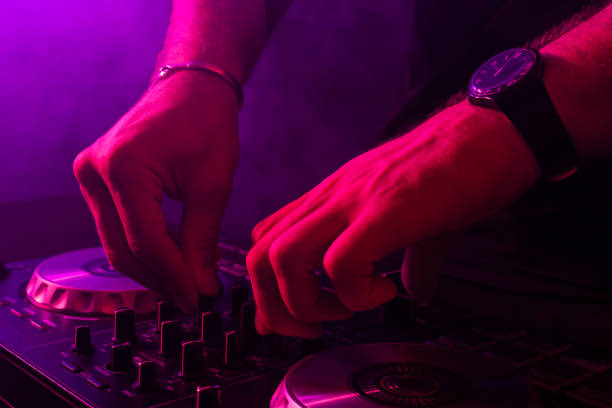 istock Dj mixing on turntables with color light effects. Soft focus on hand. Close-up 1011399396