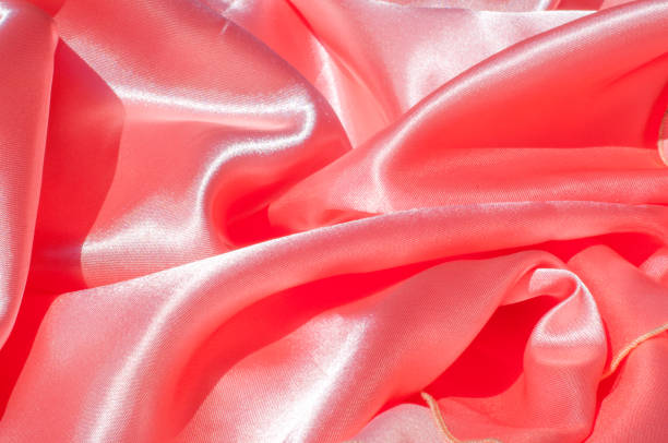 istock Texture, background, pattern. Lining female dress light orange, lining cloth orange. Fabric coral silk 1011404994