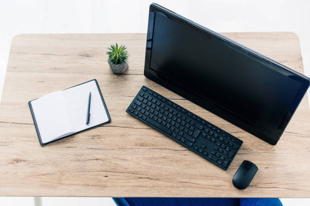istock elevated view of empty textbook, potted plant and computer on wooden table 1011411110