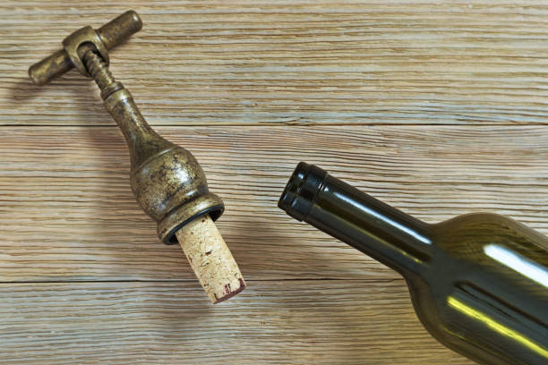 istock Vintage corkscrew with cork and an open bottle of wine 1011415860
