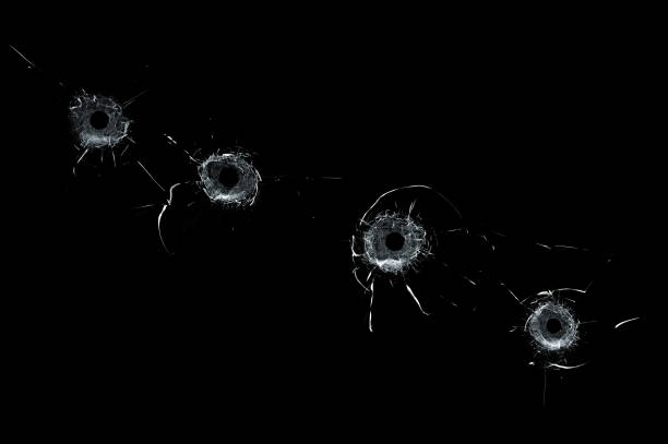 Broken glass multiple bullet holes in glass isolated on black stock photo