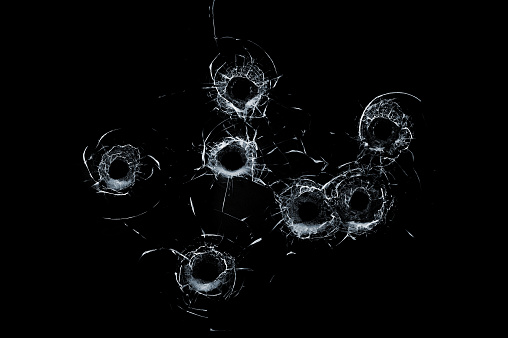 Cristal quebrado varios agujeros de bala en el vidrio aislaron en negro photo