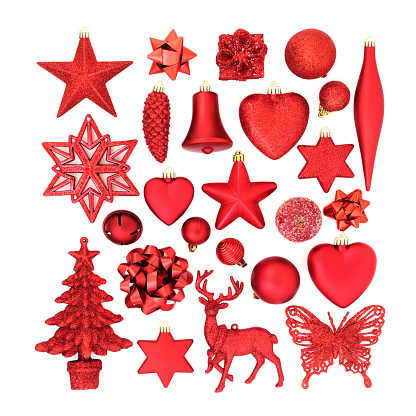 Red Christmas tree decorations, baubles, ornaments and symbols for the festive season on white background. Flat lay.