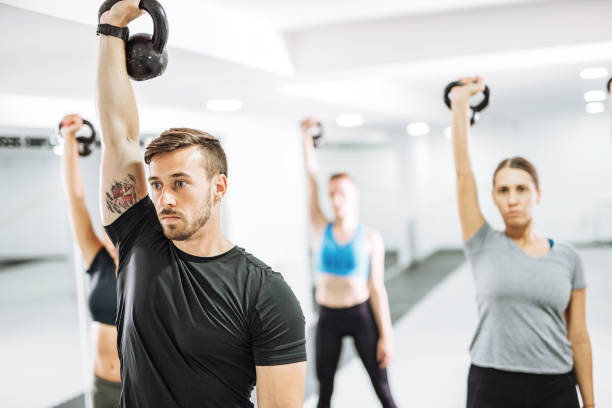 istock Young female instructor on fitness class with kettlebells 1011419412
