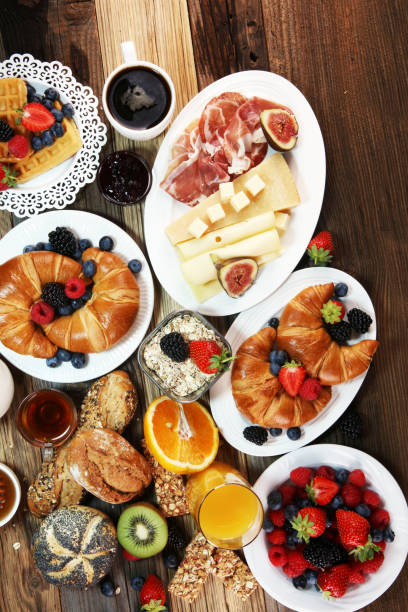 istock breakfast on table with waffles, croissants, coffe and juice. 1011419780