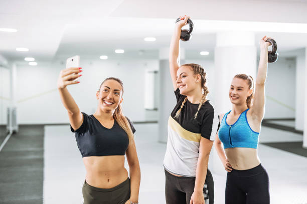 Girls on fitness class with kettlebells Young people - teenagers and young adults exercising on cross training with variety of exercises crossfit girl stock pictures, royalty-free photos & images