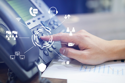 close up employee call center man hand point to press button number on telephone office desk with virtual communication technology concept