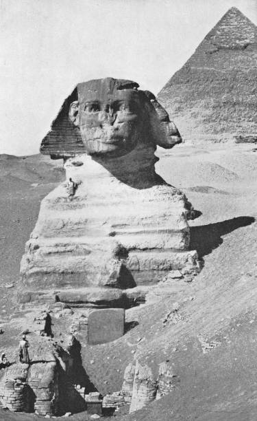 Pyramid of Khufu and The Sphinx at the Great Pyramids in Giza, Egypt. Vintage halftone etching circa late 19th century. The Sphinx is still partially buried in the desert sand.