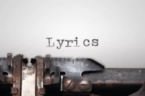 Word "Lyrics" written on paper, with an old typewriter. Horizontal orientation. Close up view.
