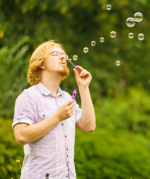 istock Man blowing soap bubbles outdoor 1011447230