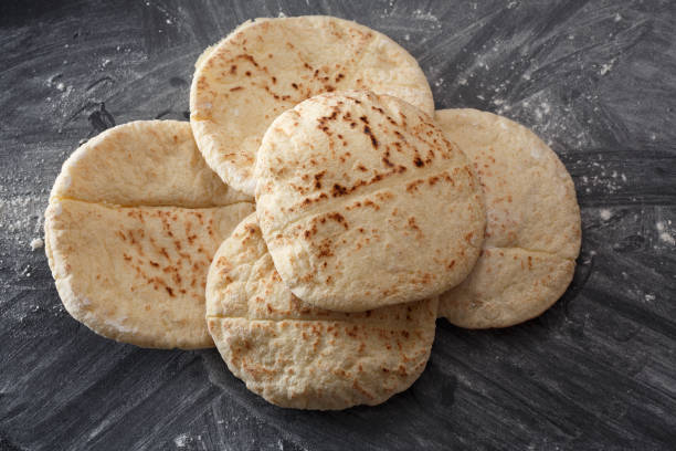 istock Pita bread on a black table sprinkled with flour 1011452086
